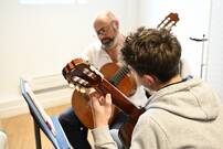 un professeur et son élève jouant de la guitare