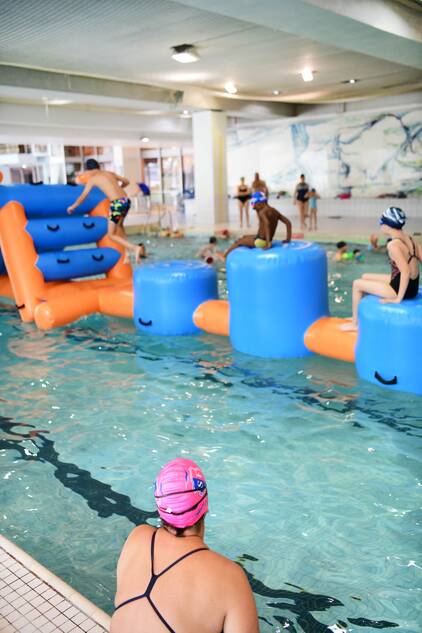 Activités ludiques petit bassin à la piscine de Courbevoie Parcours sur une structure gonflable géante à la piscine de Courbevoie.