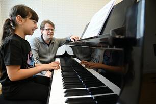 professeur avec élève jouant du piano