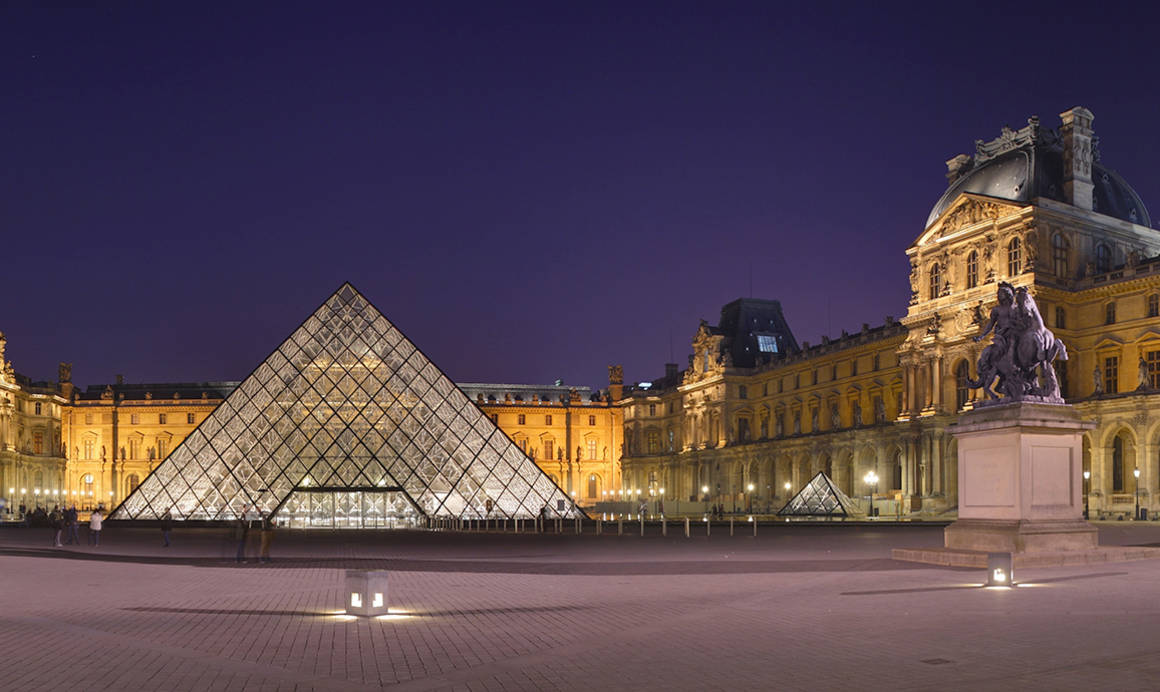 Photo Paris 16 commons.wikimedia.org La cour Napoléon du Musée du Louvre, et sa pyramide, à la tombée de la nuit