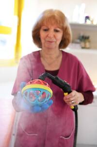 Photo d'une femme de la petite enfance qui nettoie un jouet