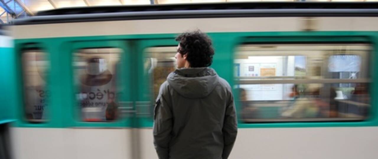 Photo d'un homme qui se tient sur le quai du métro pendant que le métro passe