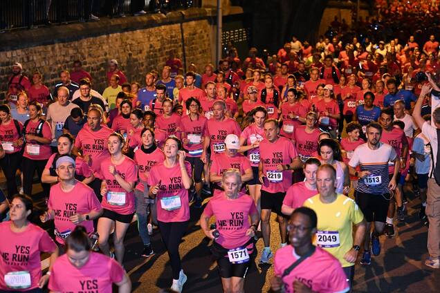 Photo vue du dessus d'une foule de coureurs portant un t-shirt rose à la yes we run 2024 dans les rues de Courbevoie