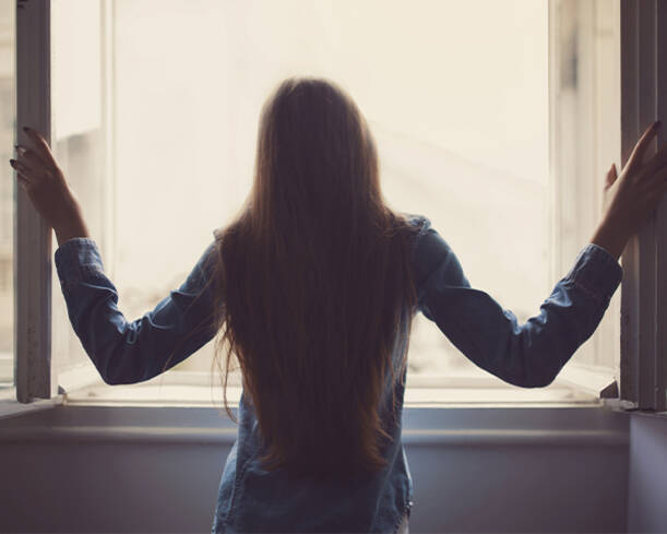 Photo d'une femme qui regarde par la fenêtre 