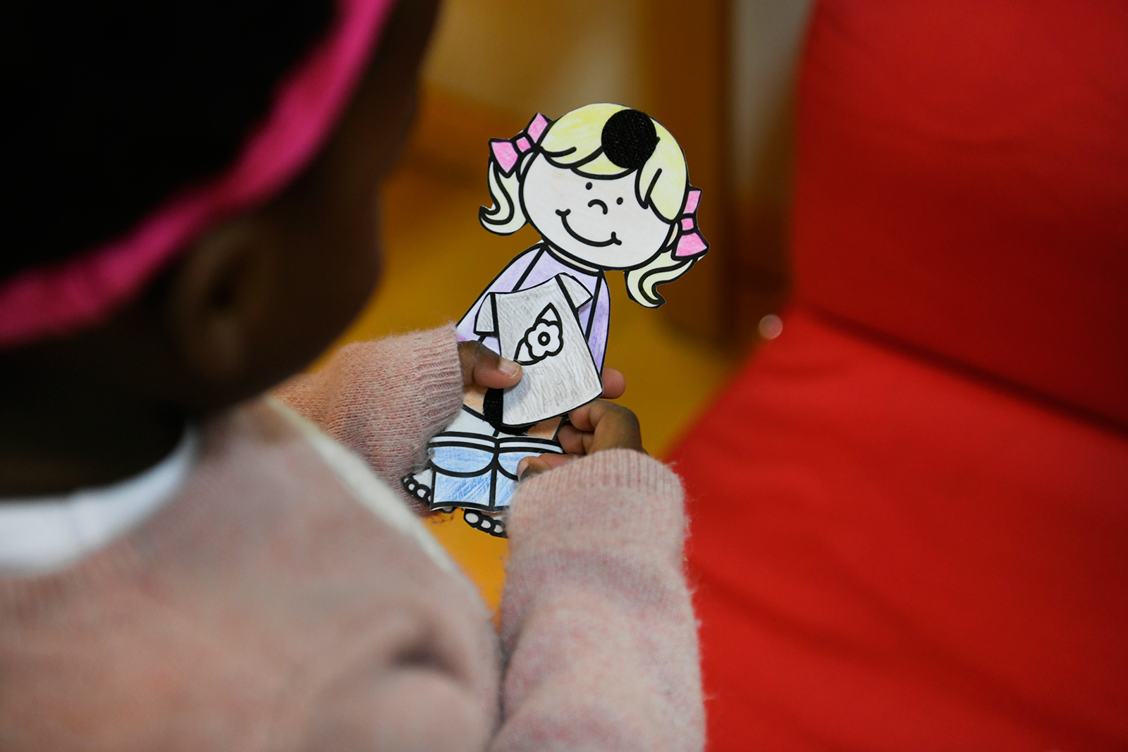 Enfant à la crèche qui tient un personnage en papier découpé